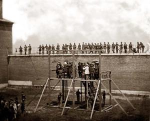 Four soldiers wait below the gallows to "spring the trap"