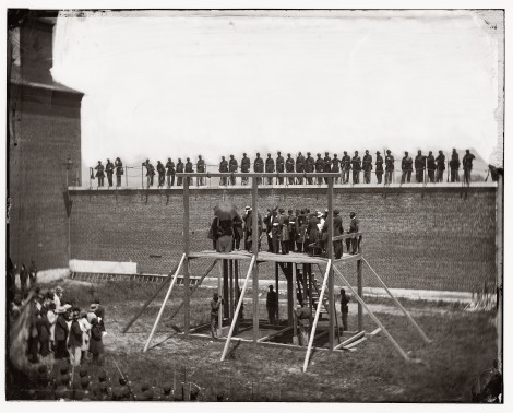 Alexander Gardner's photograph "Arrival at Scaffold" with William Coxshall beneath the gallows on the front left side.